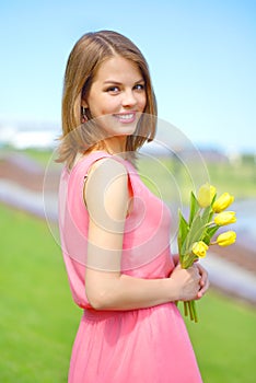 Smiling girl with yellow tulips