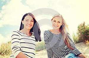 Smiling girlfriends having fun on the beach