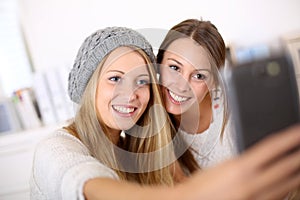 Smiling girlfriends taking selfie