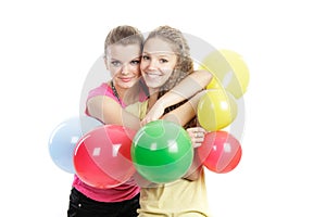 Smiling girls with balloons over white