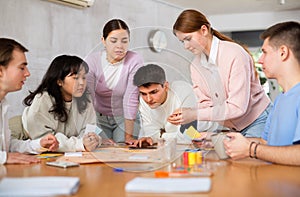 Smiling girls and boys play board games in classroom