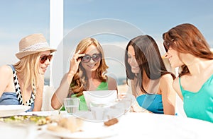 Smiling girls looking at tablet pc in cafe