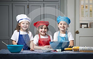 Smiling girls with mixing bowls and rolling pins