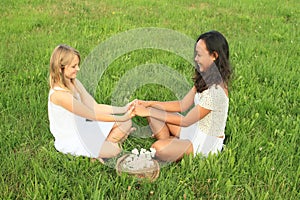 Smiling girls sitting on grass