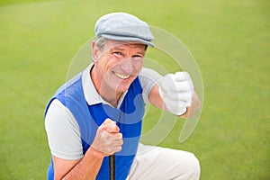 Smiling golfer kneeling on the putting green