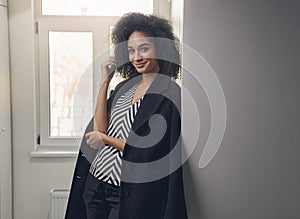 Smiling good-looking young business lady standing indoors