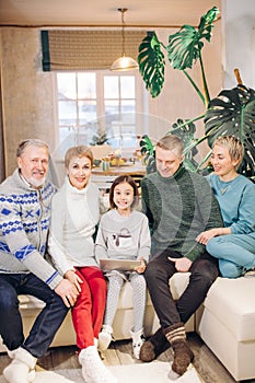 Smiling gorgeous family sitting on the couch with a laptop