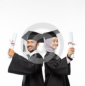 Smiling graduate boy and girl in black toga holding certificate