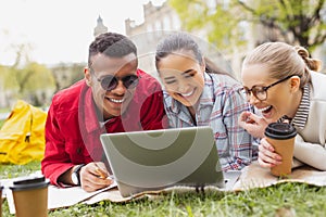 Smiling graduates watching comedy in the park