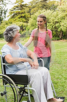 Smiling granddaughter with grandmother in her wheelchair