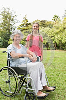 Smiling granddaughter with grandmother in her wheelchair