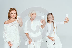 smiling granddaughter, mother and grandmother taking