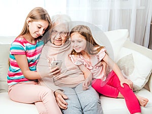 Smiling granddaughters with great-grandmother