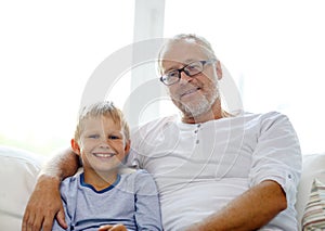 Smiling grandfather and grandson at home