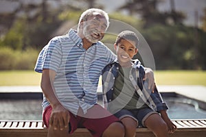 Smiling grandfather and grandson sitting together on bench