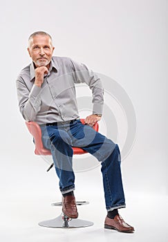 Smiling grandfather sitting in a studio