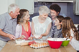 Smiling grandmother cooking food with family