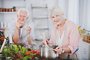 Smiling grandmother cooking tomato soup