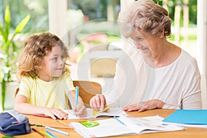 grandmother drawing with crayons with a young grandson