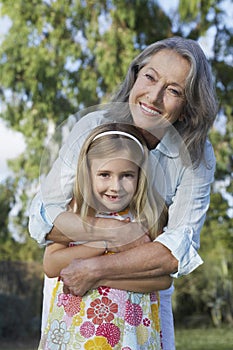 Smiling Grandmother With Granddaughter Outdoors