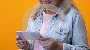 Smiling grandmother watching old photos, admiring memories, history remembrance