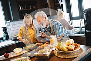 Smiling grandparents having breakfast with their granddaughter