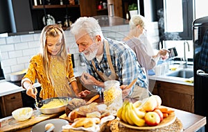 Smiling grandparents having breakfast with their granddaughter