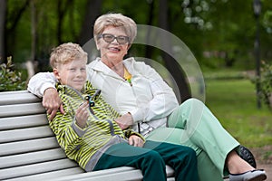 Smiling grandson playing with spinner gadget, happy grandma hugging boy, two persons