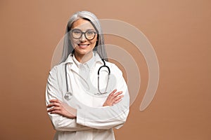 Smiling gray-haired Asian female doctor pediatric, physical, therapist wearing white medical gown