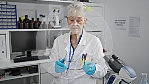 Smiling grey-haired senior woman scientist exudes confidence, taking glasses off amidst her laboratory work, embodying the secure