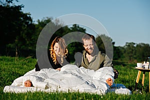 Smiling groggy couple waking up from a nap in bed made outside in a countryside photo