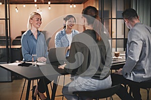 Smiling group of businesspeople working around an office table