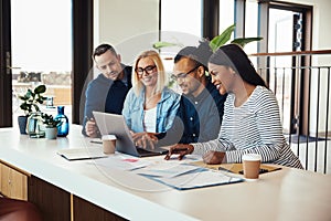 Smiling group of businesspeople working together at an office ta