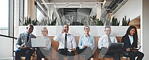 Smiling group of diverse businesspeople waiting in an office rec