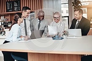 Smiling group of diverse businesspeople working around an office