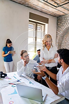 Smiling group of diverse businesspeople working together around a meeting table in an office