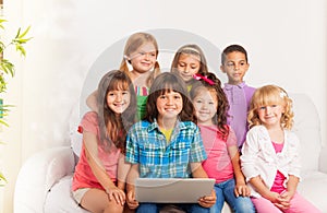 Smiling group of kids with laptop