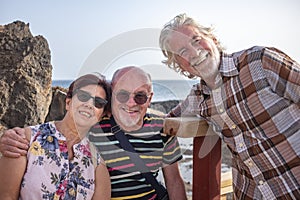 Smiling group of senior people looking at camera enjoying sea excursion. Active lifestyle for three retired people