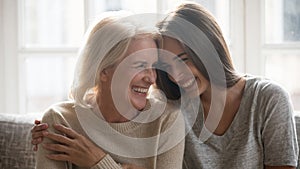 Smiling grownup daughter and elderly mom have fun laughing