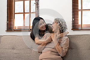 smiling grownup daughter hugging older mother. two generations concept, beautiful young woman embracing mature woman