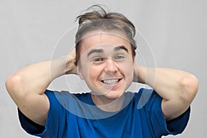 Smiling guy holds his head