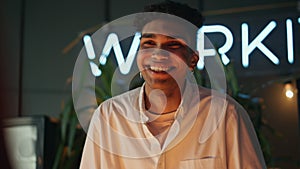 Smiling guy laughing at night bar closeup. African american man feeling happy