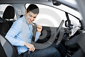 Smiling Guy Putting On Seat Belt Sitting In Car