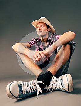 Smiling guy in sneakers and hat