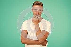 smiling guy with trendy hairstyle has colored graying hair and groomed face on turquoise background, hairdresser