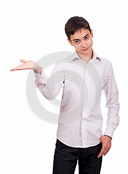 Smiling guy in white clothes on a white background looks at the camera and shows an empty palm. Cheerful young man in white shirt