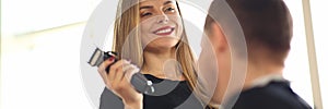 Smiling Hairdresser Using Electric Razor to Client