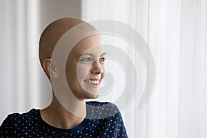 Smiling hairless female patient look in distance dreaming