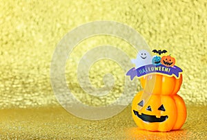 Smiling halloween jack o lantern pumpkin on a glitter golden background.