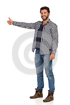 Smiling Handsme Man In Jeans And Unbuttoned Lumberjack Shirt Is Showing Thumb Up